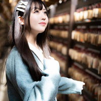 絵馬の前で願い事をする彼女の写真