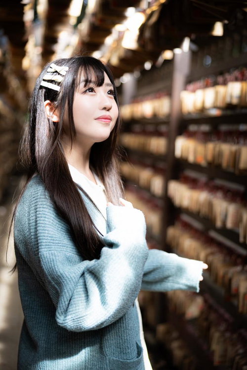 絵馬の前で願い事をする彼女