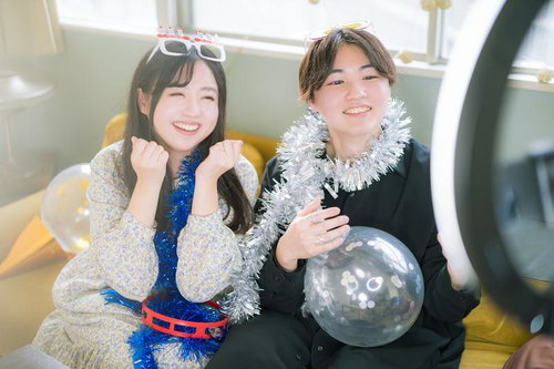 リングライトにスマートフォンを取り付けて配信する男女カップルが笑顔で楽しむ