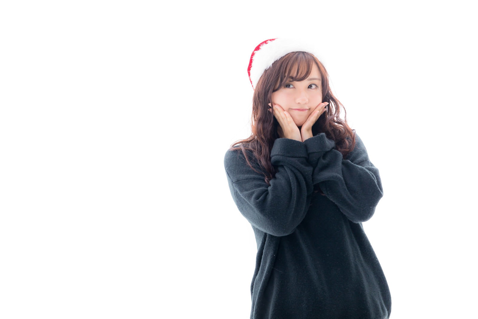 サンタ帽をかぶり緑色のセーターを着た女性が胸の前で手を合わせている［モデル：河村友歌］