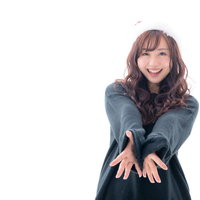 緑色の衣装を着て笑顔で迎えるサンタ女子のクリスマスの写真