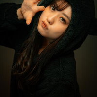 黒い猫耳フードをかぶってポーズを取る女性の写真