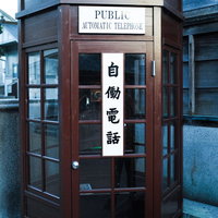 PUBLIC AUTOMATIC TELEPHONEと書かれた赤い公衆電話ボックスの写真