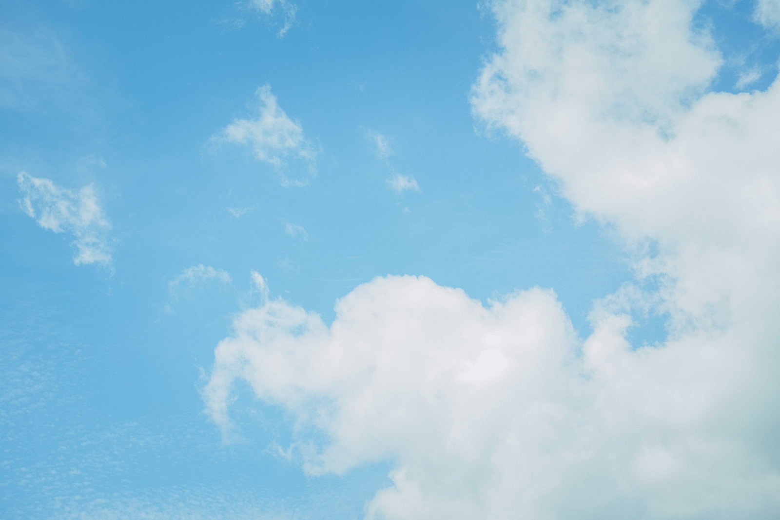 青空に浮かぶ白い雲が広がる晴れた空の風景