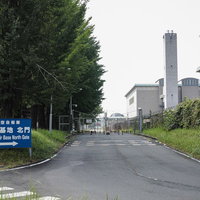 道路脇に設置された航空自衛隊入間基地の青い看板の写真
