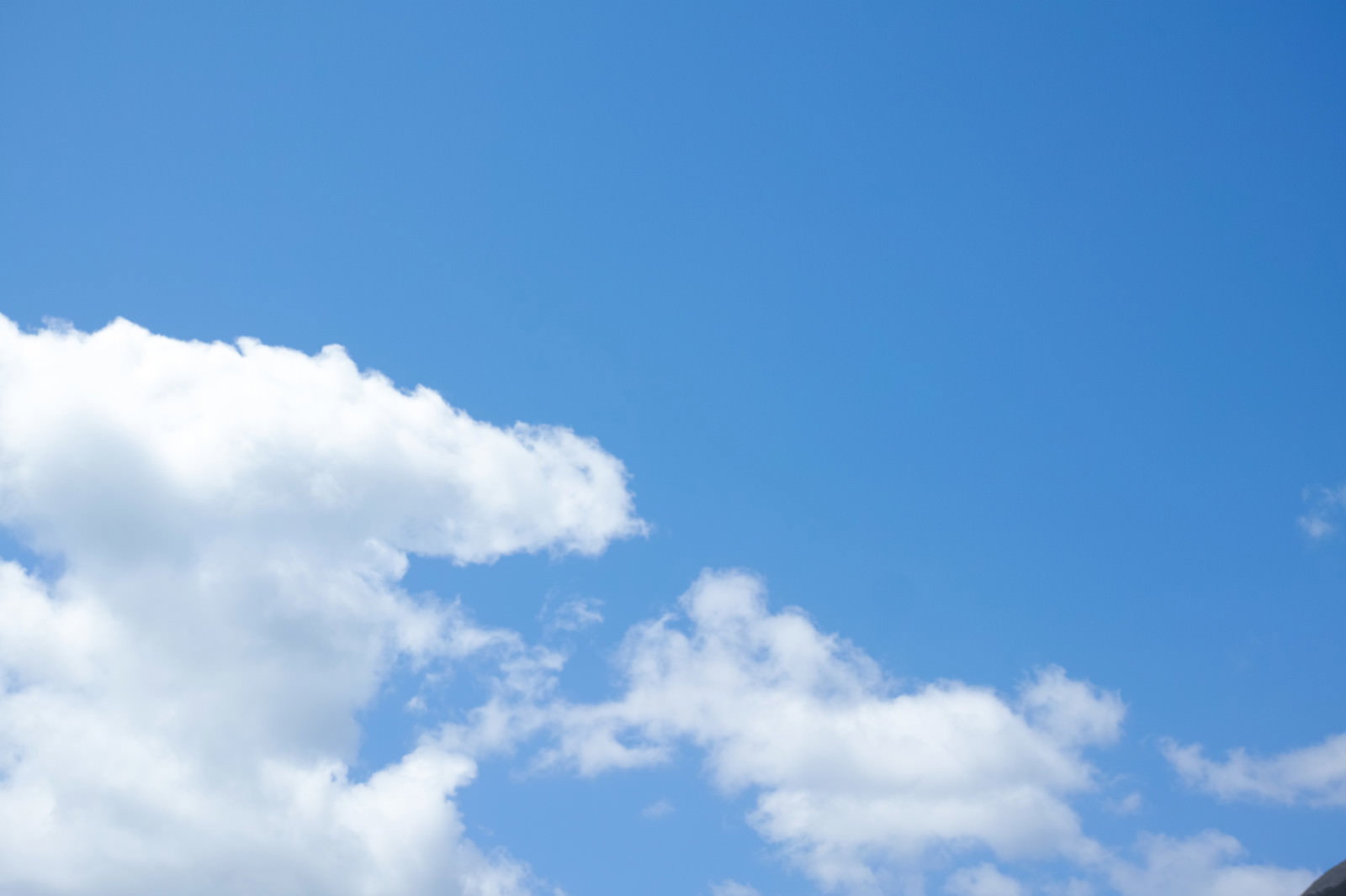 鮮やかな青空に白い雲が浮かんでいる様子