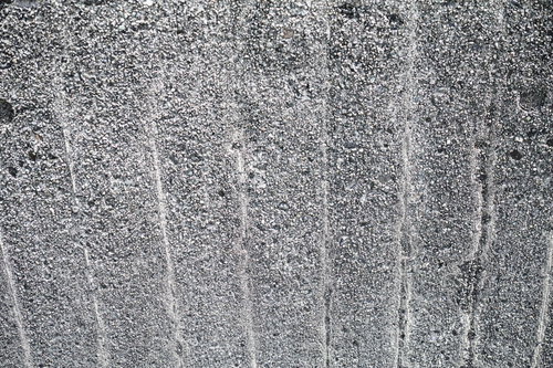 上下に傷が残るグレーのコンクリート壁のテクスチャ