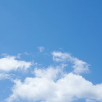 大きな空に浮かぶ白い雲の一部が青空に映える風景の写真