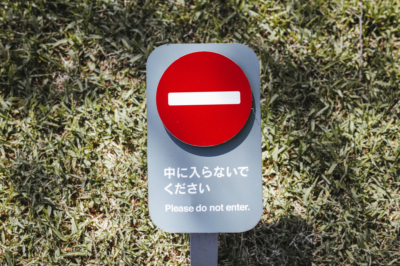 赤い円に白い横線の進入禁止標識と日本語の注意書き