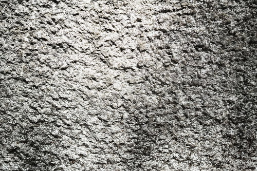 黒い汚れが付いたボコボコのコンクリート壁のテクスチャ