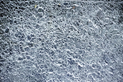石材が埋め込まれたアスファルトとコンクリート地面のテクスチャー