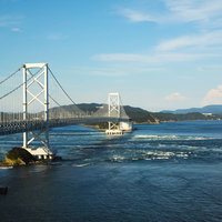 大鳴門橋と鳴門海峡に発生する白い渦潮の絶景の写真