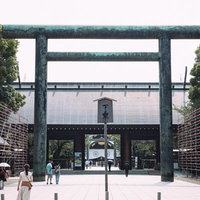 靖国神社の大鳥居と参拝者が行き交う境内の風景の写真
