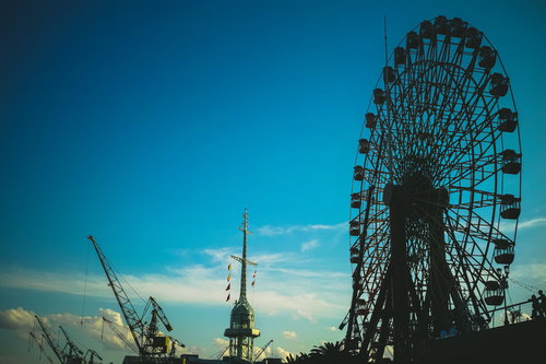 青空に映る観覧車と鉄塔の風景