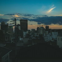 夕暮れと静まる街並みのシルエット、オレンジ色に染まる空の写真