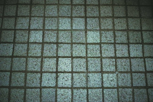 薄暗いグレー系タイルの床テクスチャー