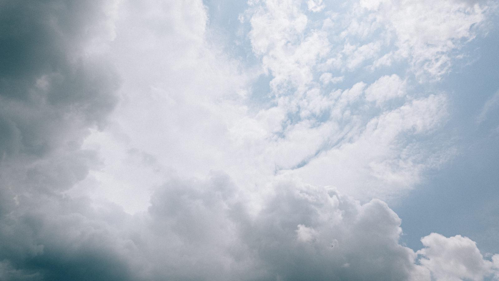 白い積雲が規則的に広がり、青い空に晴れ間が見える風景