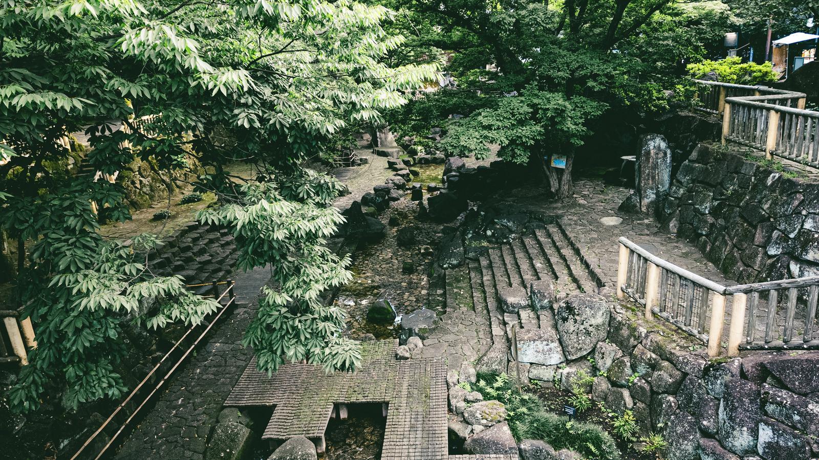 舟串橋から眺める音無親水公園の石段と石垣に囲まれた緑の園地