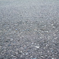細かい石や砂利が混じったアスファルトの路面テクスチャーの写真
