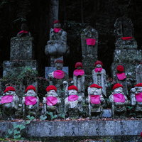 赤い帽子とよだれかけを身に着けたお地蔵様の写真