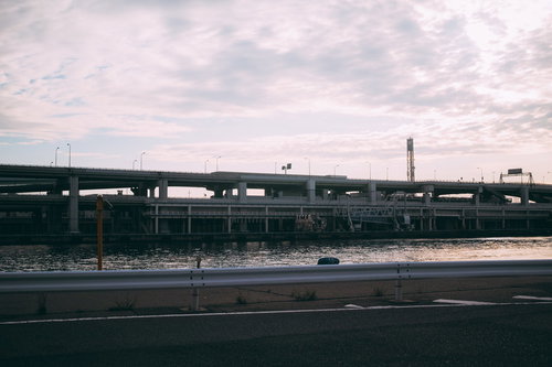 光る水面と高速道路のガードレール、夜間の橋梁インフラ