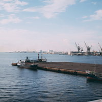 晴れた空と埠頭に停泊している船舶が見える港の写真