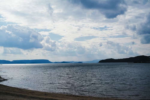 穏やかな海面に映る白い雲と遠い山並み