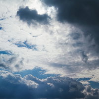 厚く覆う灰色の雲の曇り空、グレーの重い天気の写真