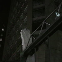 建築現場の鉄筋と鉄骨に結ばれた白い足場幕の写真