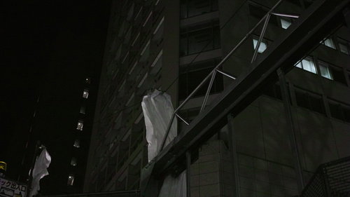 建築現場の鉄筋と鉄骨に結ばれた白い足場幕