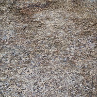 白く浮かび上がる岩石の表面と岩肌のテクスチャーの写真