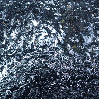 雨が降ったあとのアスファルトの路面の写真