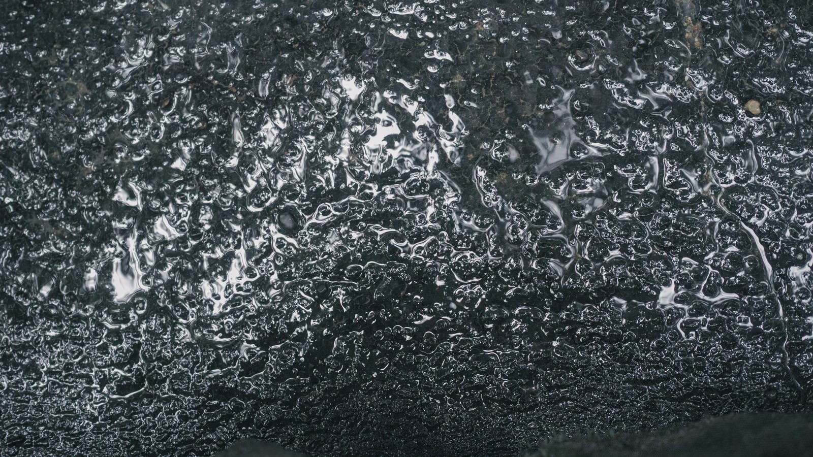 水分を含んで湿った状態のアスファルトの質感