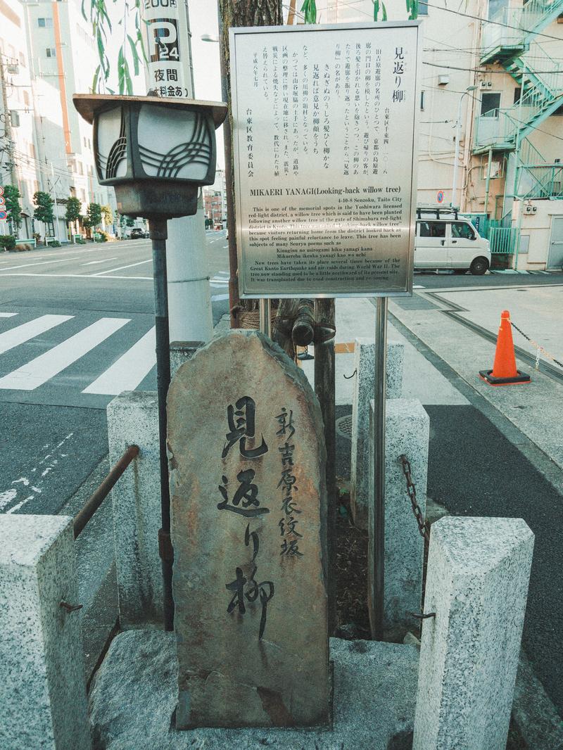 新吉原衣紋坂に立つ見返り柳の碑と説明板の街道風景