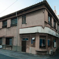 台東区千束4丁目の角に立つ古い住宅街の建物の写真