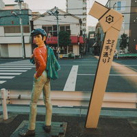 土手通りに立つあしたのジョー像と交差点の商店街風景の写真