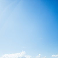 見上げた霞む青空のグラデーションの写真