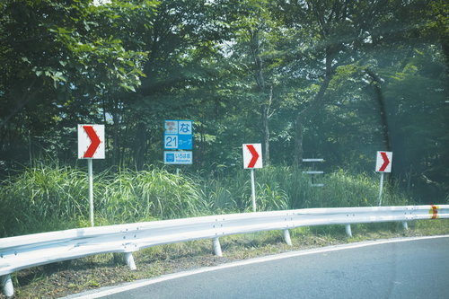 栃木県いろは坂のカーブ標識とガードレール