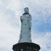 青空を背景に見上げた世界平和大観音像の写真