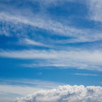 流れる白い薄雲と快晴の青空の写真