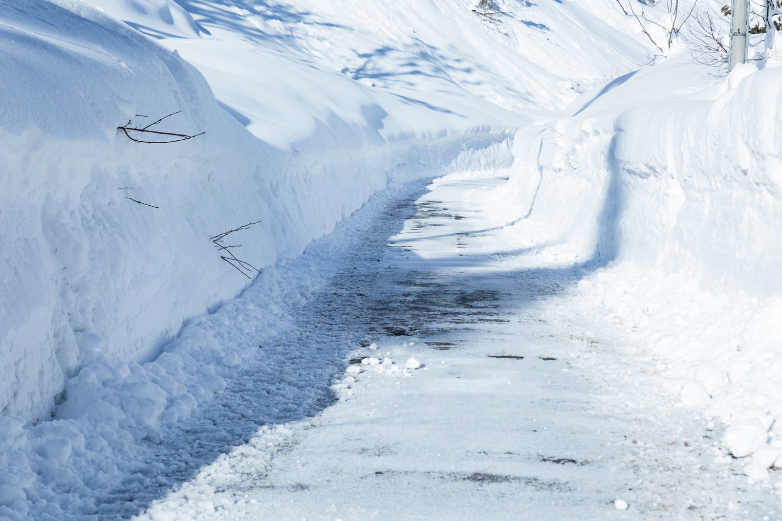 雪に覆われた山間部の除雪された道路が蛇行している様子