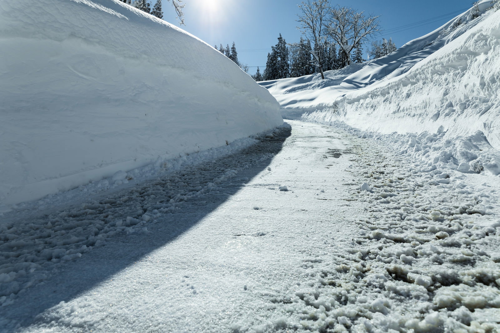 道路の両側に高く積み上げられた除雪後の雪の壁