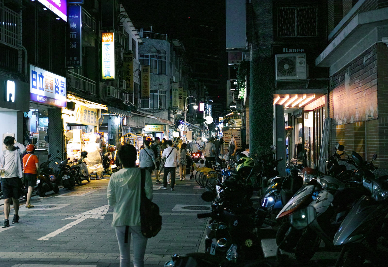 夜の台湾の繁華街で人々が行き交う雑居な街並み
