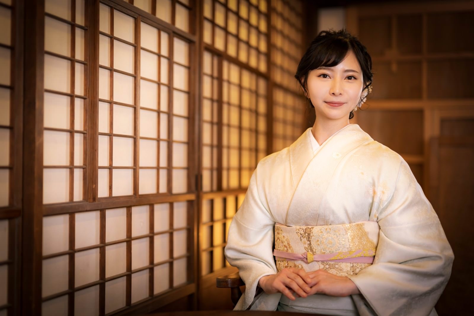 障子のある和室で淡い着物を着て正座する女将［モデル：yumiko］