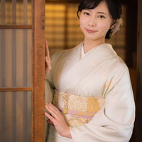 そっと旅館の扉を開ける着物姿の女将が客をお迎えするの写真