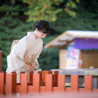神社で一礼する白い着物の女性の写真