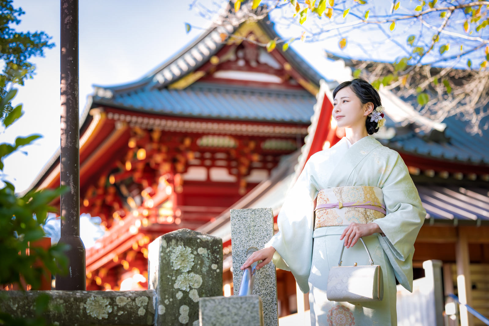白い着物を着た女性が神社の境内を歩いている様子［モデル：yumiko］