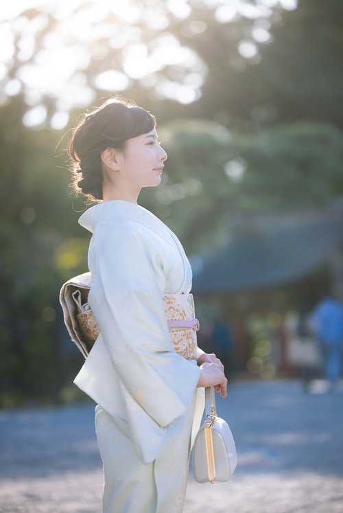 白い着物を着た女性の横顔、神社境内での参拝