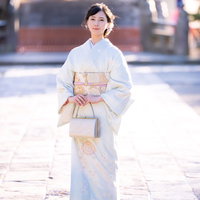 神社の境内を歩む着物姿の女性の全身ショットの写真