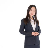 紺色スーツで微笑む受付の女性の写真